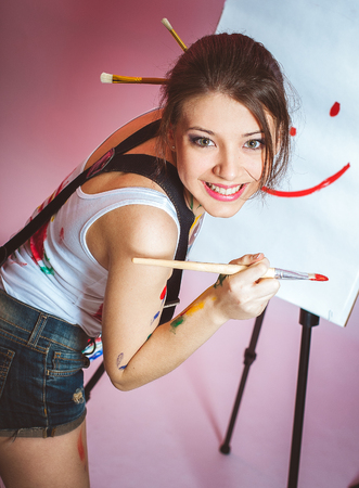 Her young girl with a brush, bright emotions.の写真素材