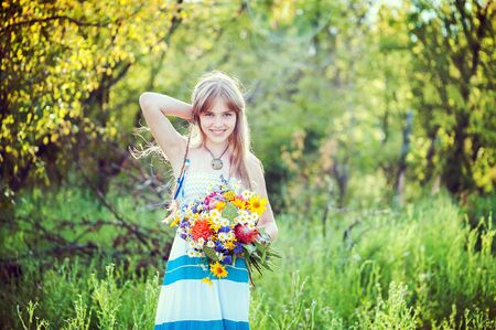 Young girl posing with a beautiful bouquet of summer garden. Family vacation conceptのeditorial素材