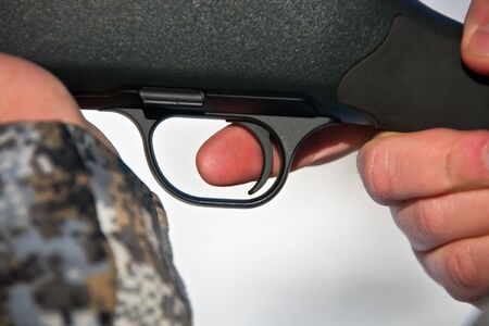 Finger on the trigger. The index finger on the trigger of a hunting rifle when shooting.