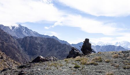 Hunters in camouflage suits secretly with binoculars are searching for animals in the mountains. Two...