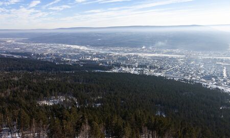 Siberian city between the taiga hills in the floodplain of the Lena river. The city of Ust-Kut at the beginning of winter.の写真素材