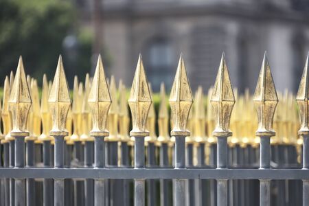 Rhythm of yellow gold tips of the metal fence of the territory. Arrows or spears of a stylized iron fence. Design, Tips of the metal fenceの写真素材
