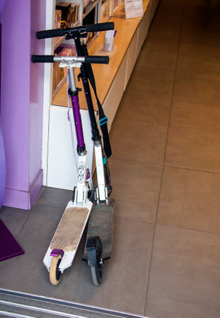 Two scooters at the entrance to the store. A pair of scooters in the parking lot. Male and female scooters are parked in the corner. Paris, France, Europe,の写真素材