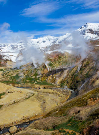 Spring landscape with columns of steam and gases in the Valley of Geysers. Active volcanic activity and thermal fields in the floodplain of the Geysernaya River in Kamchatka.の写真素材