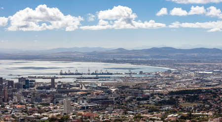 Panorama of the coast and the seaport in the bay in Cape Town. Berthing facilities with pier, cranes and container ships in the port of Cape Town.の写真素材