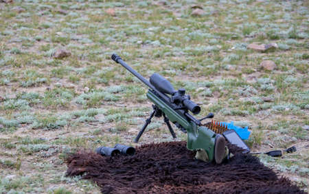 High-precision hunting rifle with an optical sight, cartridges and binoculars on the sighting....