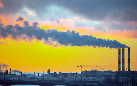 Smoke from industrial chimneys and a heavenly landscape at sunset. Colored smoke from chimneys against the background of evening clouds in the frosty winter air.の写真素材