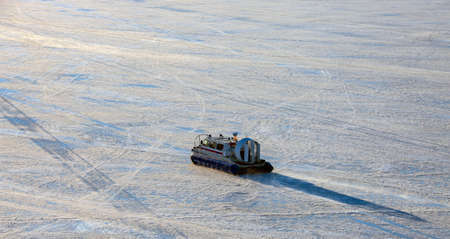 Rescue Service hovercraft is moving on the ice surface. Rescue service vehicle with an aero engine...