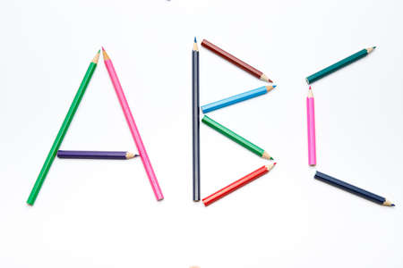 Simple letters a, b and c made of small color pencils on white uniform background, simple numbers...