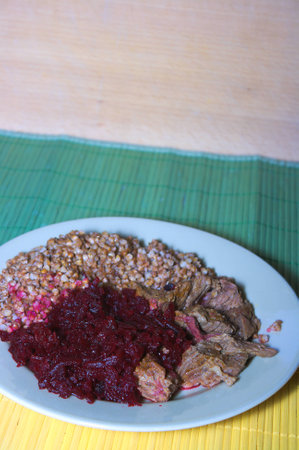 goulash with buckwheat and beets on plateの写真素材