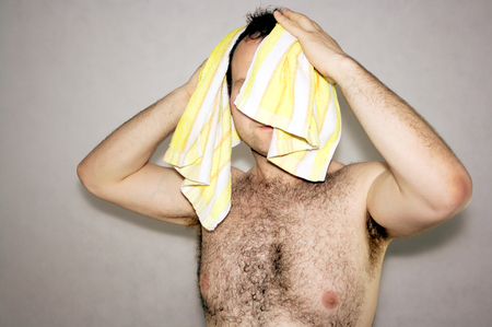 Man dries head towel on whiteの写真素材