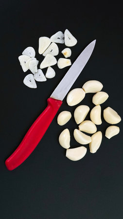 Fresh peeled garlic cloves arranged on a black background with ample copy space. Perfect for cooking, healthy food, seasoning, recipe, and culinary concept projects.