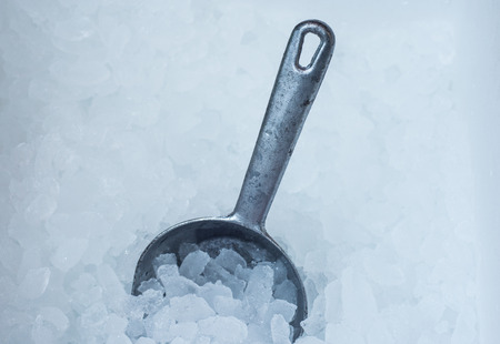 Metal spoon on ice cube backgroundの写真素材
