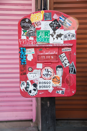 Maehongson, Thailand - December 11, 2016: Dirty red old mailbox stand between pink and red steel wallのeditorial素材