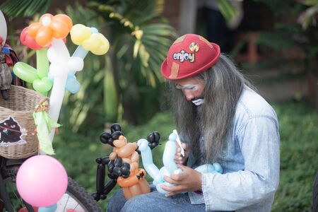 Chiangmai, Jing Jai Market, Muang Chiangmai, Thailand- December 02, 2018: A  clown creating free form, and animal balloons at Jing Jai Market, the organic market, Muang District, Chiangmai, Thailandのeditorial素材