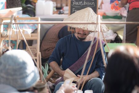 Chiangmai, Jing Jai Market, Muang Chiangmai, Thailand- December 02, 2018: A  blur smiling man in Thai suite  making a drip coffee at Jing Jai Market, the organic market, Muang District, Chiangmai, Thailandのeditorial素材