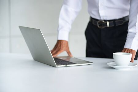 Blur Asian Business old man with white shirt  is and drinking coffee, working with labtop, thinking, planning, and meeting at the office about the success of the companyの写真素材
