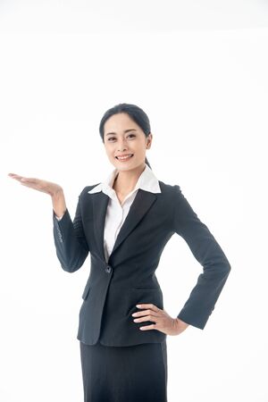 Asian beautiful smart  and young businesswoman with black long hair and suit  is the executive or manager show her hand and smiling with confidence  in successful on isolated white backgroundの写真素材