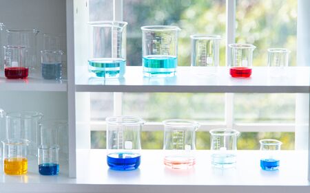 Preparing Laboratory equipments such as glassware, tube with blue and liquid on the white table. The...