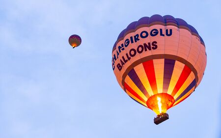 Goreme, Turkey - December 31, 2019: Tourists riding the colorful hot air balloon which it is flying over Goreme, Cappadocia  landscapeのeditorial素材