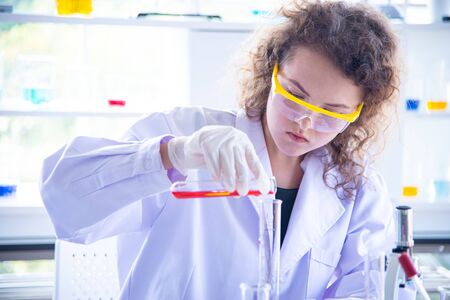 Beautiful young scientist biologist or researcher putting personal protective equipment to prevent infection from virus or bacteria disease.  The researcher testing and reseach the new virus vaccineの写真素材