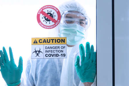 COVID-19, Corona Virus outbreak quarantine epidemic spread and social distancing concept. Asian doctors wear PPE  with CORONA or COVID-19 patient infection in the hospital quarantine roomの写真素材