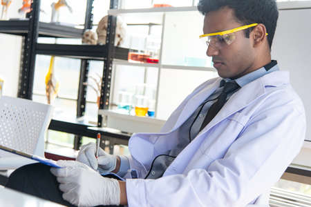 Young scientists or researchers putting personal protective equipments to prevent infection from...