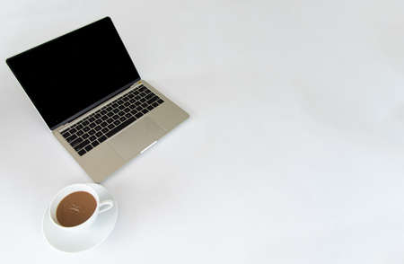 Top view of notebook or laptop and cup of coffe on white desk in meeting room.の写真素材