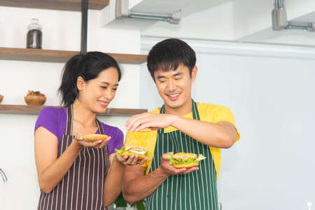 Asian romantic and lovely couple enjoy and happy cooking food in the kitchenの写真素材