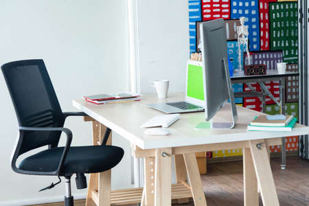 Modern computer  laptop and gadgets on the wooden table in the minimal working room. Work from home...
