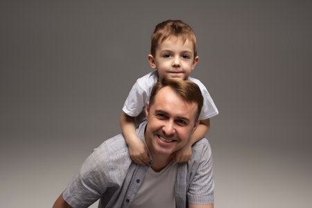 portrait of happy father and cheerful son, cute boy playing with dad in the house, child hugging father, dad playing with children, dad hugs sonの写真素材