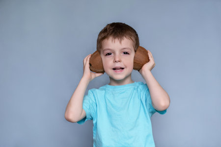 boy playing with coconut. boy eating tasty coconut. children and healthy food, children listening to...