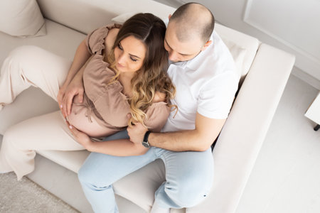 family concept. happiness concept. close-up portrait of a pregnant belly that embraces female and male hands. close-up portrait of embracing spouses. view from above.の写真素材