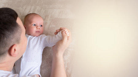 close-up dad plays with a small child at home on the bed. parent hugging a small child. family concept. copyspace; banner,の写真素材