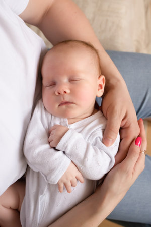dad holds a baby with a pacifier in his arms close-up portrait of a baby. young parents hold the baby in their arms. dad and mom hug a small child. happy family relaxing at home.の写真素材
