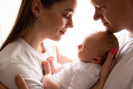 young parents hold the baby in their arms. family lifestyle photo with baby. family concept. family photo on white background.の写真素材