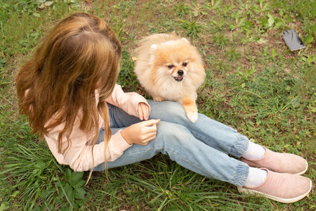 cute girl plays with a dog in nature. pets in the family.の写真素材