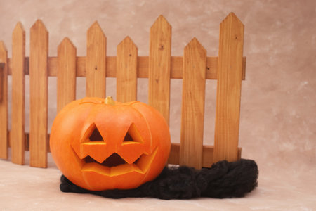 preparation for halloween, pumpkin on a beige background in a hat and halloween accessoriesの写真素材