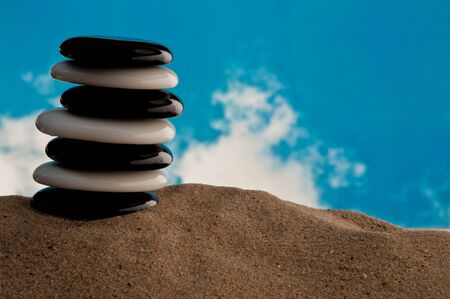 Seven polished black and white stones on a beachの写真素材