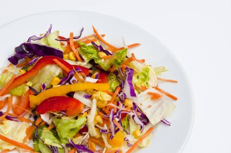 Plate of mixed salad on a round plate with a white backgroundの写真素材