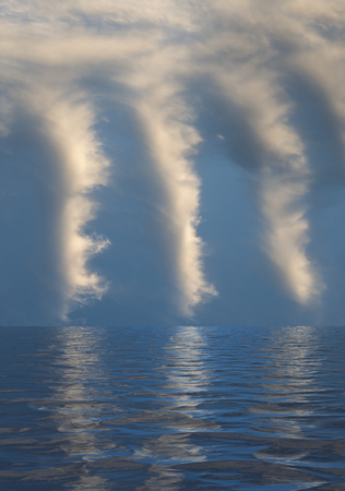 Calm sea with ripples leading to a blue sky with white cloudsの写真素材