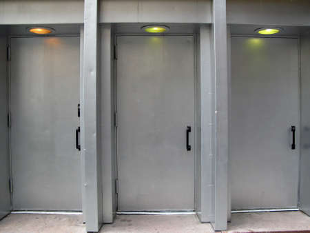 Three silver outside doors with overhead lights shot in natural daylight 