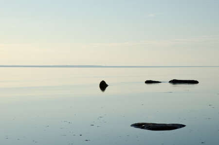 Seascape with stones in calm waterの写真素材