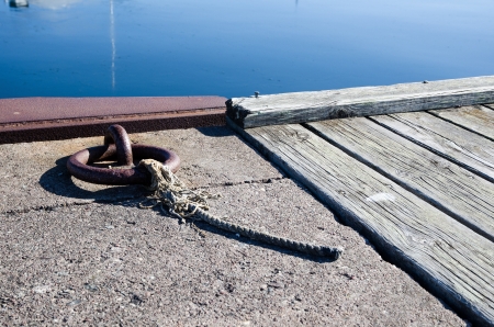 Mooring loop with a cut cord at a wooden and concrete pierの写真素材