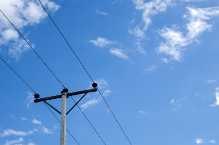 Powerlines at a blue sky with white cloudsの写真素材