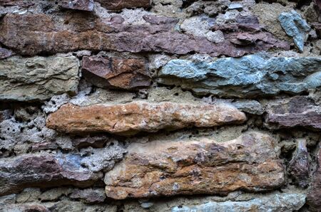 Old weathered brickwall of limestones in different coloursの写真素材