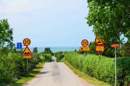 Lot of road signs at a road to the beach