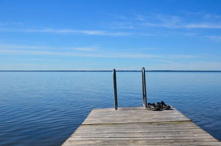 Shoes on an old jetty in the Baltic sea, Sweden の写真素材