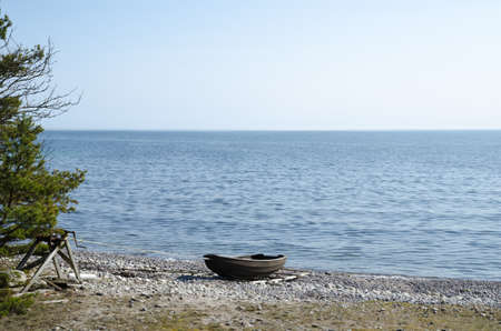 Old rowing boat beached by an old winchの写真素材
