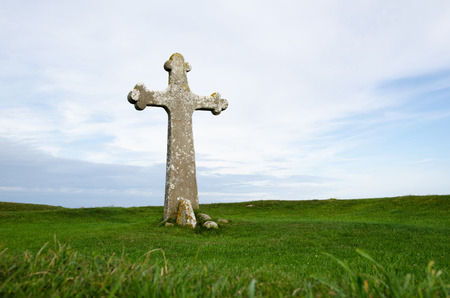 Ancient cross surrounded of green grass at the swedish island Oland in the Baltic Seaの写真素材